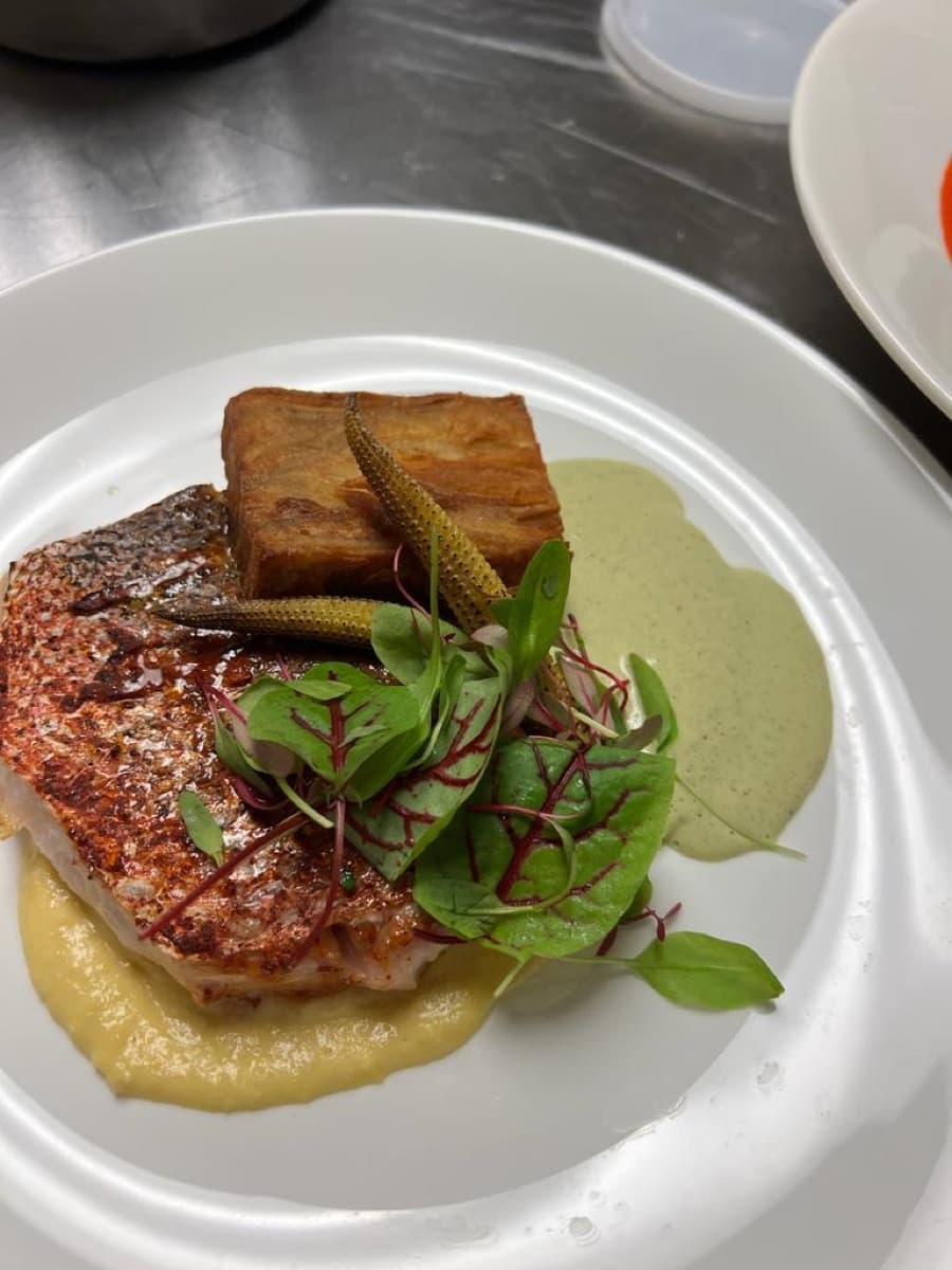 Chef Carlos plating a dish in the kitchen