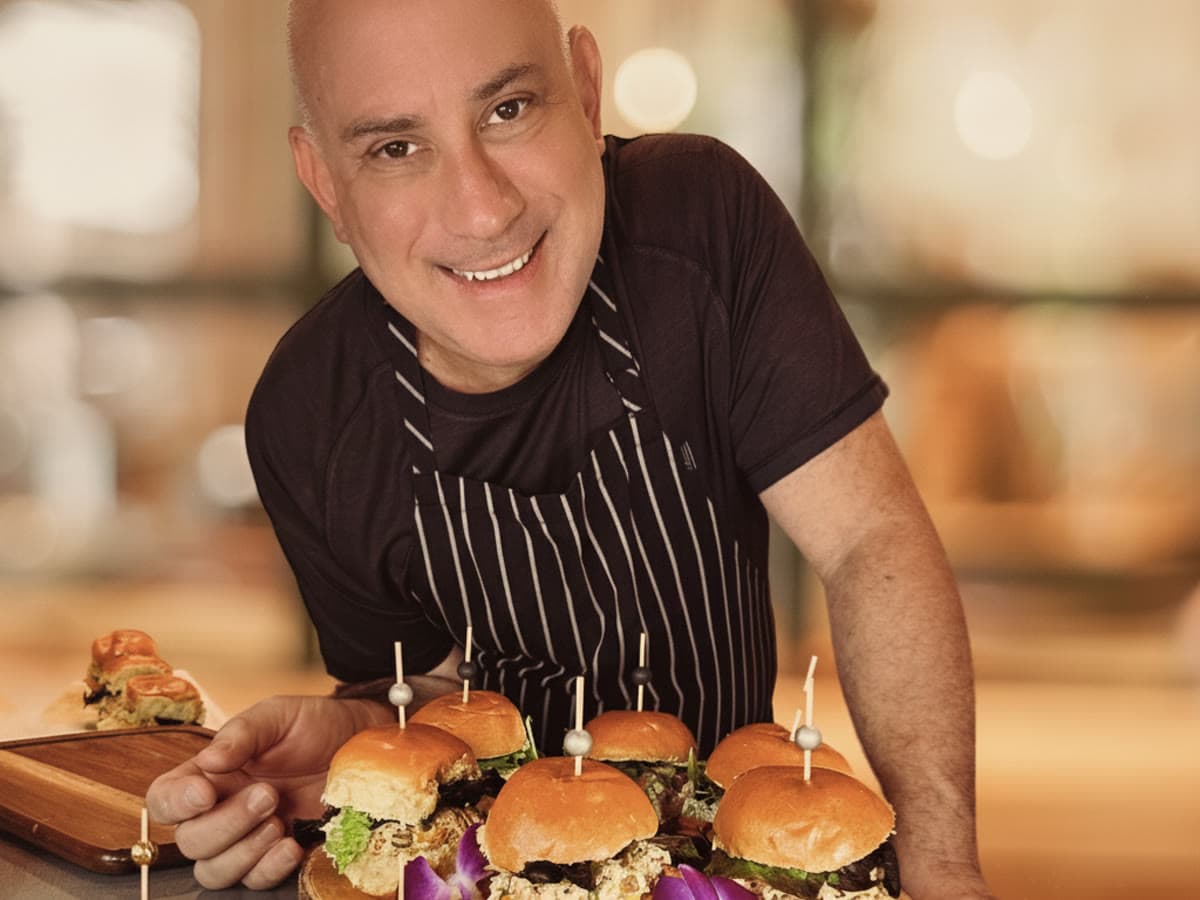 Uniformed catering staff plating a chef-driven dish on-site at a Central Florida event